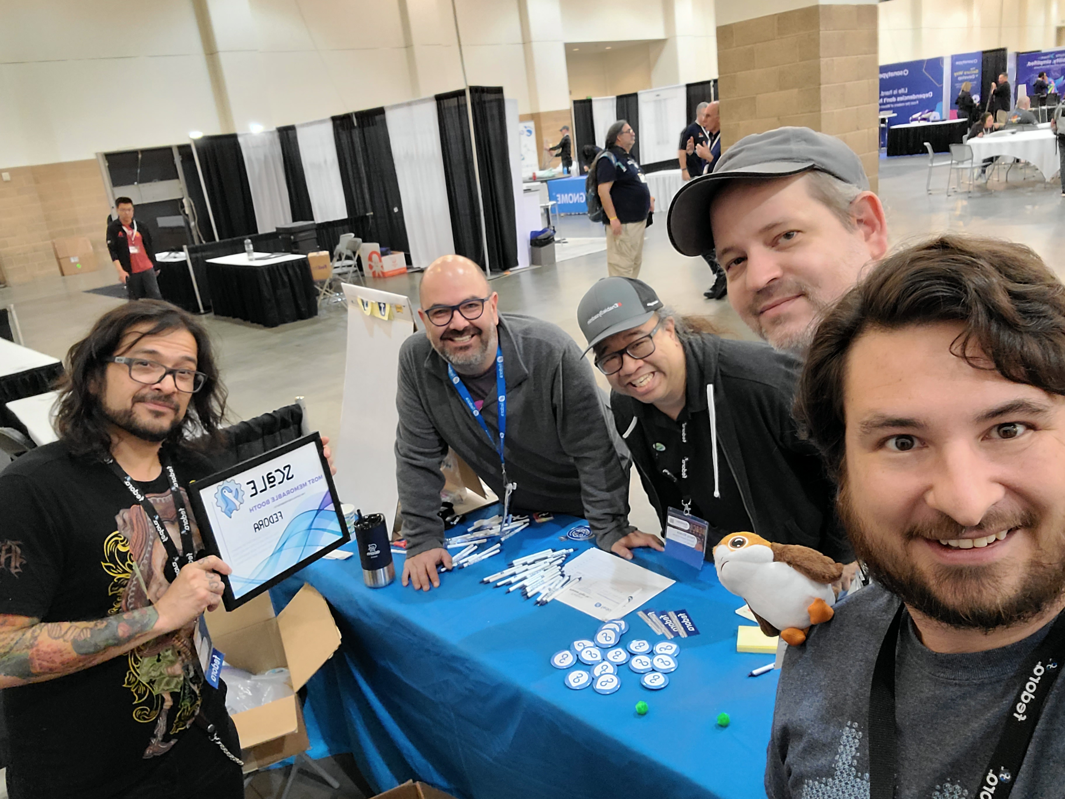 Fedora Ambassadors around a table in the exhibit hall
